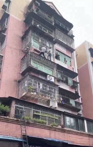 惊险！小女孩悬挂五楼窗外，邻居冒雨爬窗将其救下