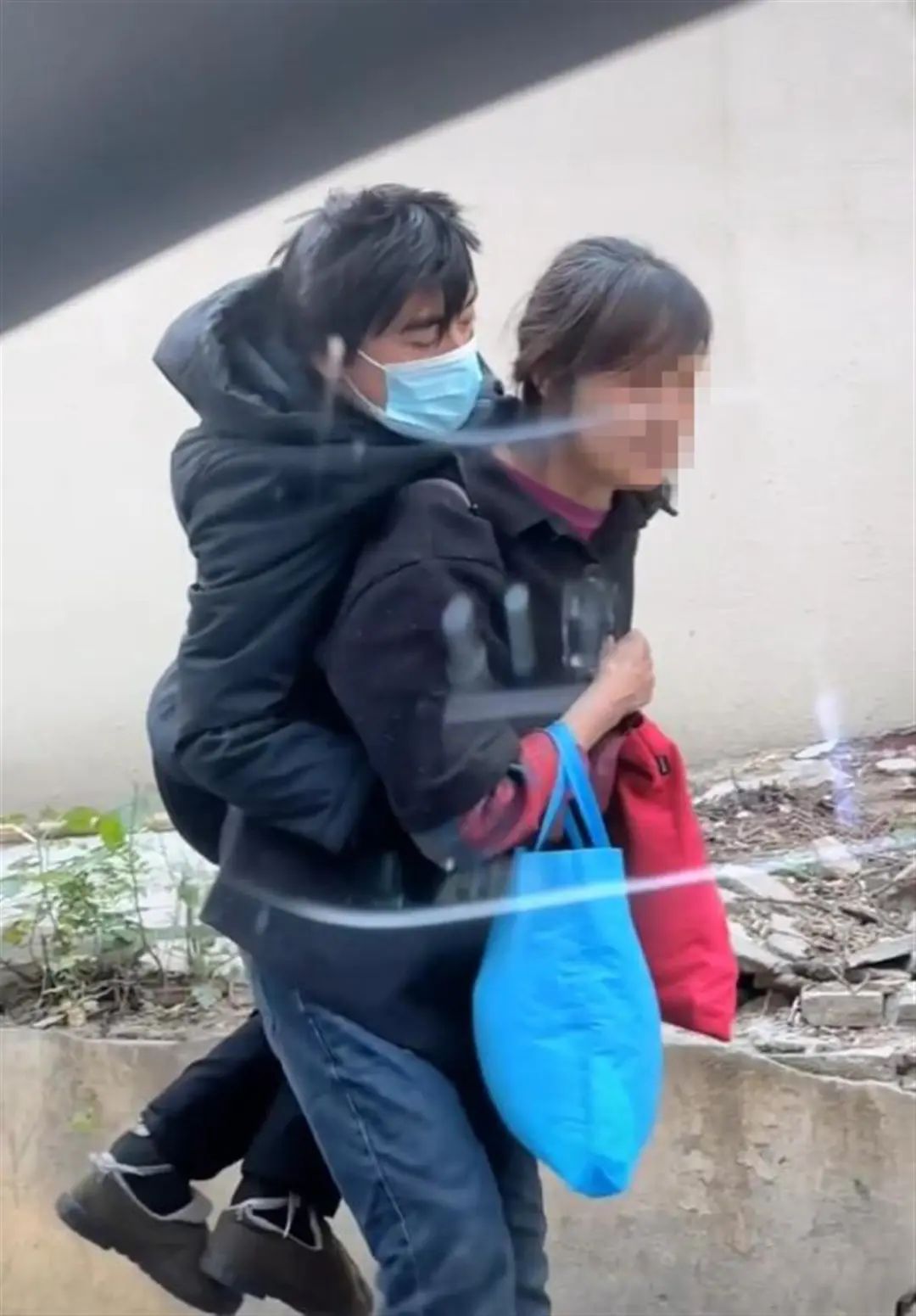 年迈母亲背着成年儿子行走引热议，官方回应